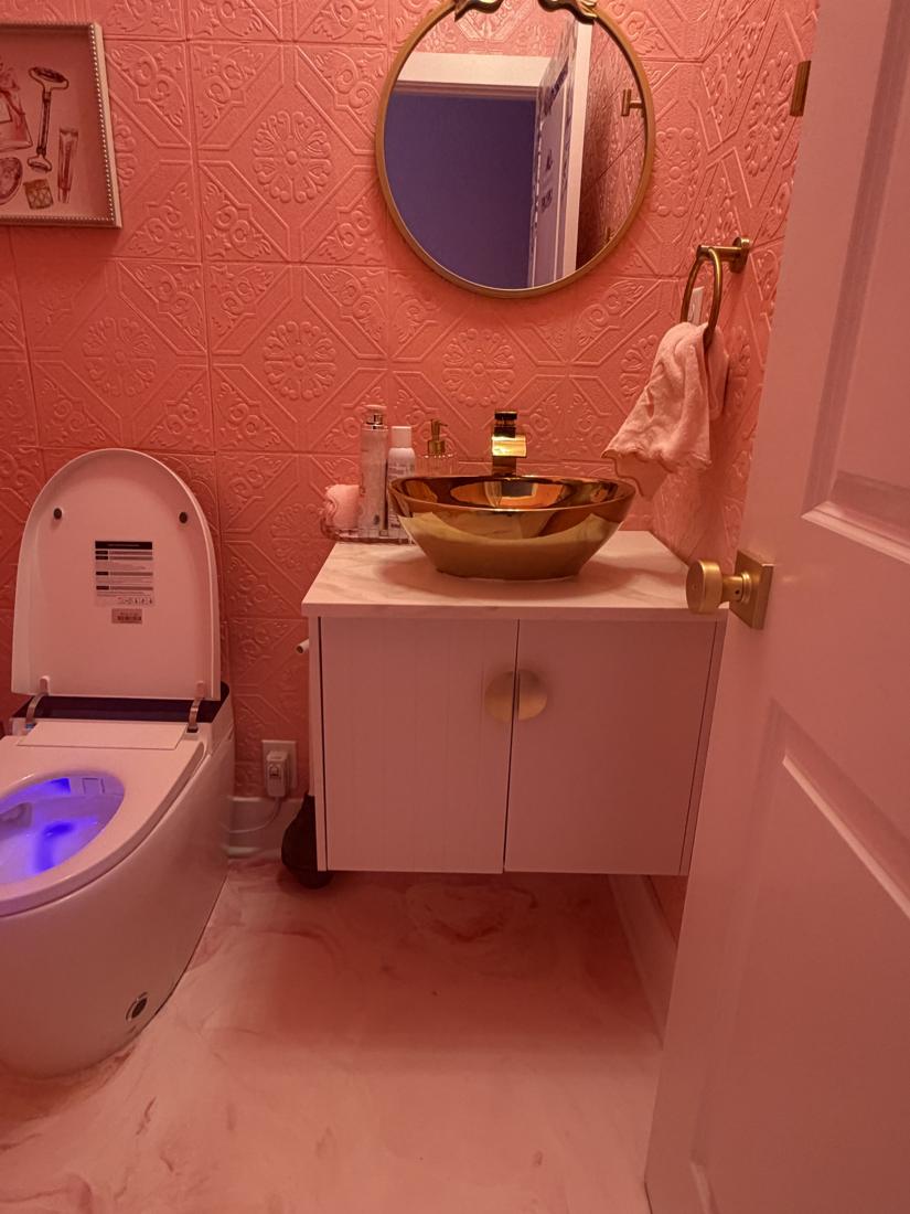 Floating vanity with gold faucet and epoxy floor
