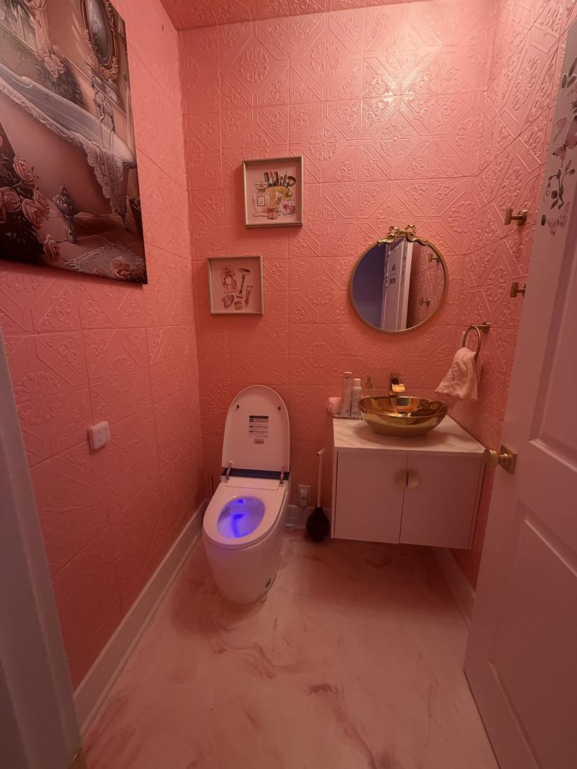 Pink powder room with gold vessel sink and floating vanity